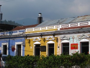 Colorful buildings along a street in La Antigua, Guatemala, Agua volcano in background