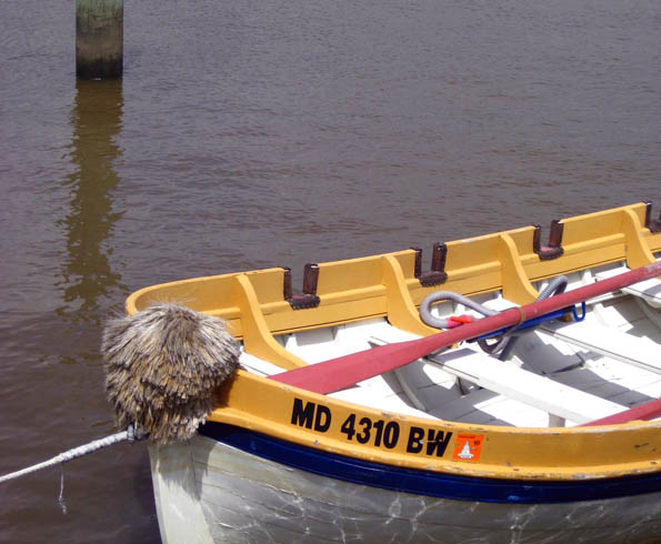Vintage wooden boat, white with yellow trim, in Chester River in Chestertown, Maryland, USA