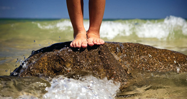 Feet on Grand Traverse Bay beach rock in Traverse City, Michigan USAFeet on beach rock in Traverse City, Michigan USA